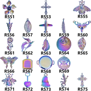 Flat lay of rainbow plated DIY metal charms in flower, bee, and cross shapes
