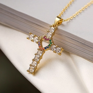 Vue macro du collier croix en or avec cœur ajouré et pierres en zircon multicolores