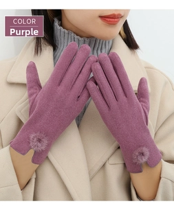 Detail of purple winter gloves with decorative pompom and elegant V-shaped wrist opening
