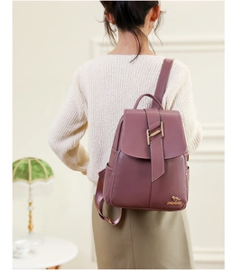 Detail showing the litchi grain texture and gold kangaroo logo on the purple backpack
