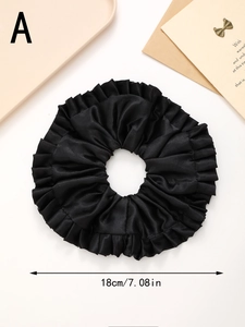 Détail d'un grand chouchou en satin noir avec mesure du diamètre de 18cm affichée