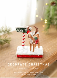 Close-up of a festive resin reindeer ornament with a North Pole sign on a snowy base
