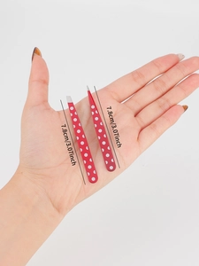 Detail showing two polka dot stainless steel tweezers with 7.8cm size measurements
