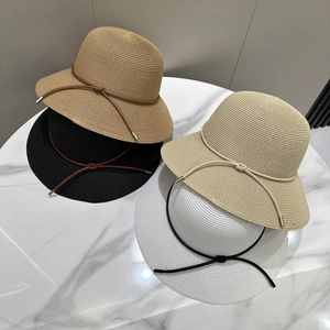 Détail macro de chapeaux de soleil montrant le tissage fin et les cordons décoratifs