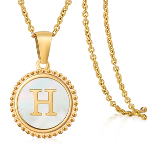 Macro detail of 18K gold stainless steel pendant with white shell and letter H