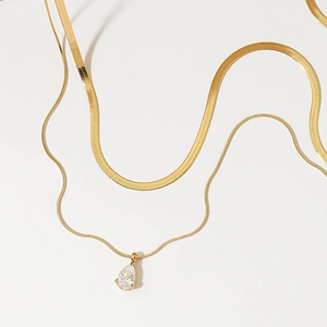 Double-layered gold snake chain necklace with a sparkling teardrop zircon pendant