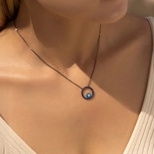 Sterling silver necklace featuring a round blue evil eye pendant on a dark metal chain