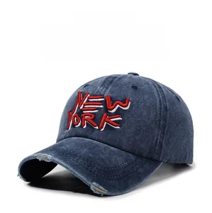 Detail of distressed navy blue washed denim baseball cap with red New York embroidery