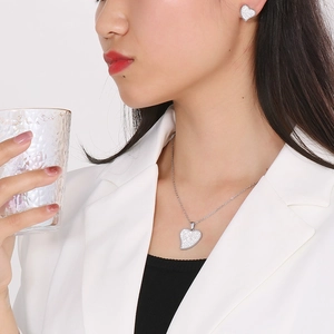 Silver heart necklace and earrings set with sparkling pavé crystals on a female model