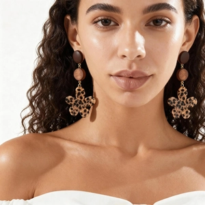 Gros plan de boucles d'oreilles rétro en résine léopard et bois sur un mannequin
