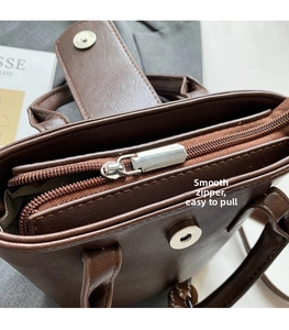 Detail of vintage brown bucket bag showing smooth metal zipper and magnetic snap closure