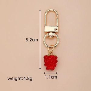 Close-up of strawberry keychain with gold lobster clasp and detailed resin fruit charm