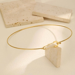 Detail view of a 18K gold stainless steel choker with a creative paperclip clasp design