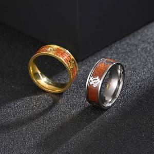 Titanium steel turtle rings with wood inlay in gold and silver on black sand