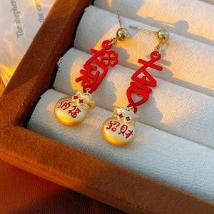 Detailed close-up of vintage enamel lucky bag earrings with festive gold Chinese calligraphy