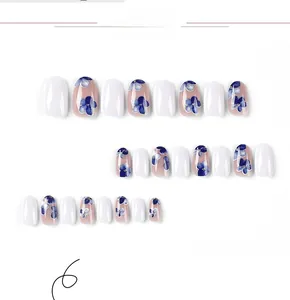 Detailed view of blue floral and solid white glossy press-on nails set in varied sizes