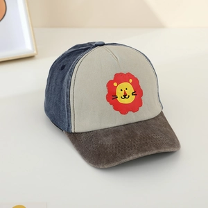 Detail of kids baseball cap with lion print, beige front and brown corduroy brim