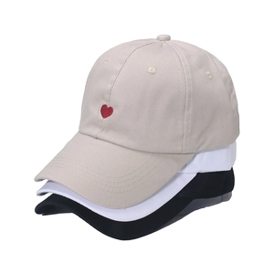 Three minimalist cotton baseball caps in beige white and black with red heart embroidery