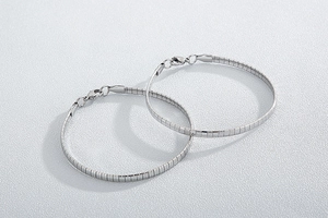 Detail of two silver stainless steel flexible chain bracelets with secure lobster clasps