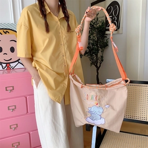 Detail of cute elephant embroidery and braided strap on the beige oxford tote bag