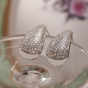Macro view of teardrop earrings with silver plating and pavé cubic zirconia setting