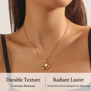 Close-up of elegant gold plated chain necklace with a white pearl in horseshoe pendant