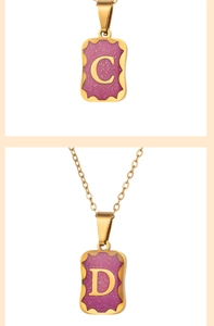 Detailed macro of gold rectangular pendants featuring purple glitter and letters C and D