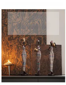 Detailed view of hand-painted geometric patterns on three African tribal woman figurines