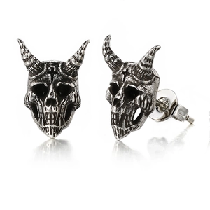 Macro view of vintage gothic skull stud earrings with detailed horned design in silver