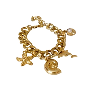 Gold ocean charm bracelet featuring starfish, dolphin, sea snail and pearl pendants