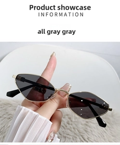 Close-up of gold metal cat-eye sunglasses with grey lenses on a soft textured background
