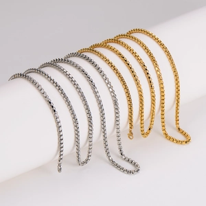 Minimalist gold and silver stainless steel box chains on white cylindrical display