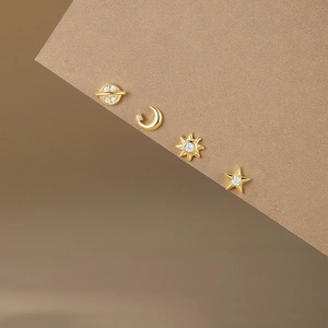 Detailed macro of gold S925 sterling silver star and moon stud earrings with white zircon