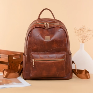 Detail of vintage brown leather backpack with textured patchwork and multi-pocket zippers