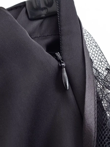 Macro view of seamless invisible zipper and black satin fabric with mesh lace detail