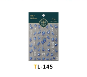 Macro detail of blue flower nail stickers with 3D pearl accents and Chinese calligraphy