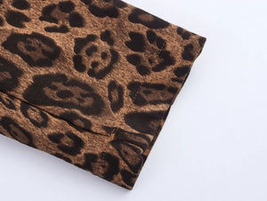 Detailed close-up of leopard print suede fabric texture and stitching on jacket cuff