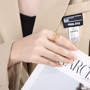Detail of a layered gold minimalist ring with sharp ends worn by a model in a suit