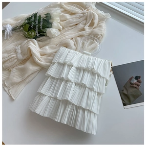 Detail of white pleated tiered handbag featuring elegant ruffles and transparent handle