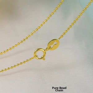 Macro shot of S925 sterling silver stamp on golden bead chain necklace detail