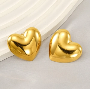 Detailed view of polished heart-shaped gold studs featuring mirror-finish surface