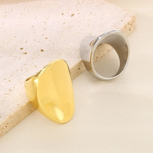 Polished minimalist gold and silver dome rings displayed on a natural stone background