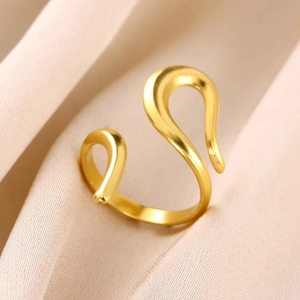 Macro detail of 18K gold plated stainless steel open ring with interwoven curves on fabric