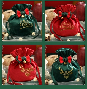 Detail of red and green velvet Christmas drawstring gift bags with bells and bows