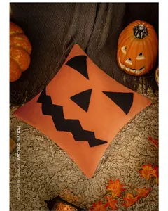 Detail of Halloween pumpkin embroidery on a plush orange throw pillow case