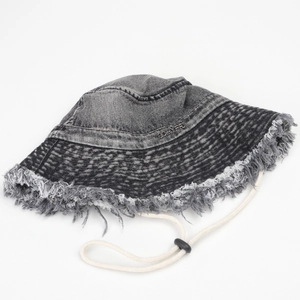 Dettaglio cappello alla pescatora in denim grigio con bordi sfrangiati e cordino