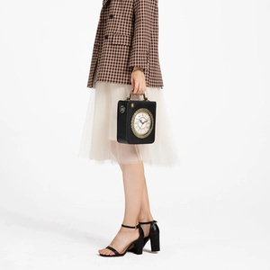 Vintage clock-shaped crossbody bag in black leather with metal handle and Roman numerals