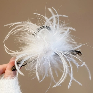Detail of white feather hair claw clip with delicate rhinestone embellishments and black base