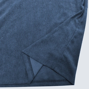Close-up of dark blue ribbed fabric texture and double-needle hem stitching on polo shirt