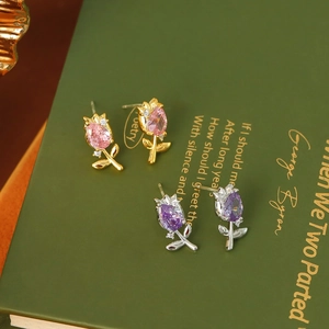 Close-up of tulip stud earrings in gold-pink and silver-purple with cubic zirconia accents